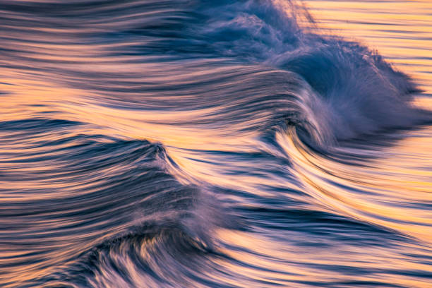 istock Artistic photograph of waves breaking in dramatic afternoon light 1323264397