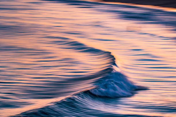 istock Artistic photograph of waves breaking in dramatic afternoon light 1323264423