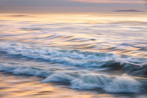 istock Rippled ocean waves and whitewash with golden surface 1323264538