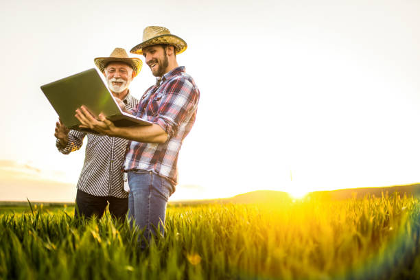 istock Two happy farmers working on an agricultural field. 1323265500