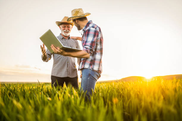 istock Two happy farmers working on an agricultural field. 1323267171