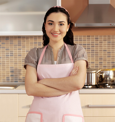 Young brunet woman with apron in domestic kitchen