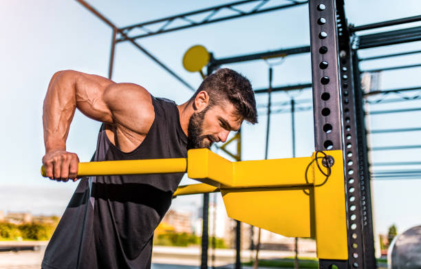 istock Young bodybuilder doing triceps workout at the outdoor gym. 1323271449