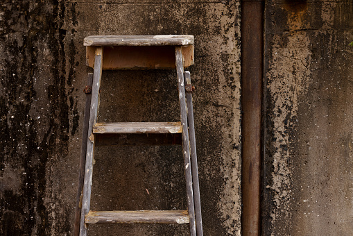 An old ladder leaning against a wall.