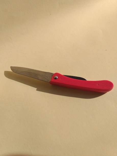 istock red penknife on a yellow background 1323281513