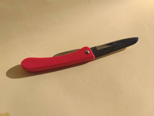 istock red penknife on a yellow background 1323281565