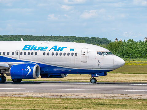 Otopeni, Romania - 05.14.2021: A Blue Air Boeing 737-5L9 (YR-BAG) airplane on the airport runway at Henri Coanda International Airport.