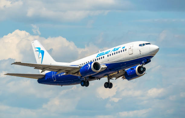 blue air boeing 737-5l9 (yr-bag) airplane takes off from henri coanda international airport - wheel airplane landing air vehicle imagens e fotografias de stock