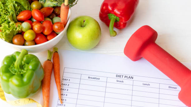 istock select focus. Diet Health Plan. Workout planning for stay at home. Sport exercise equipment workout and gym background with nutrition fresh salad for fitness style. Healthy Lifestyle Concept 1323284143