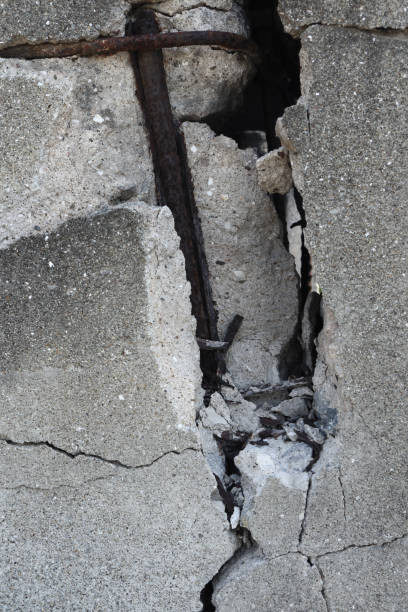istock Vertical photo of broken concrete wall with rebars. 1323285811
