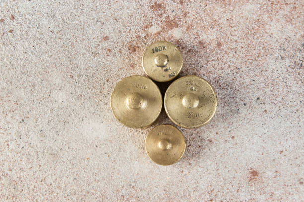 istock Antique bronze weights for scales on concrete background. 1323289442