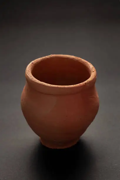 Closeup of Empty Indian Hand Made Clay Red Pot (kulhad) unglazed,  over black Background