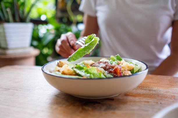 istock a woman eating a Caesar salad 1323295594