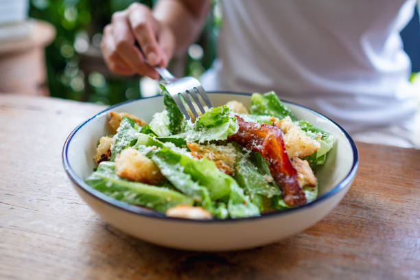istock a woman eating a Caesar salad 1323295595