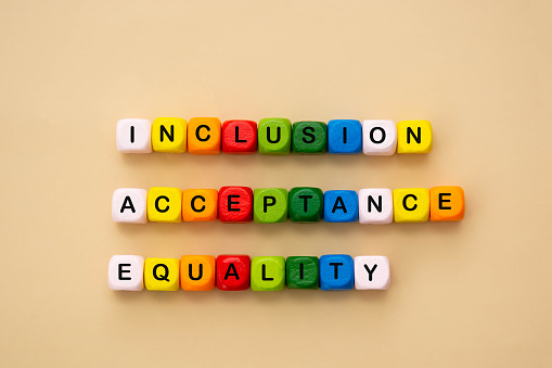 Inclusion, acceptance and equality words made from colorful wooden cubes. Inclusive and tolerance social concept.