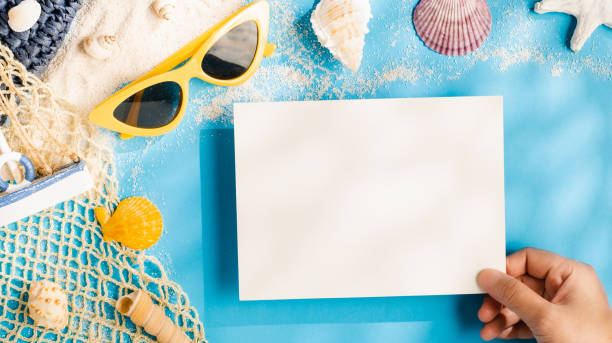 istock summer sunlight concept.hand holding blank paper on beach accessory on blue sea background 1323297814