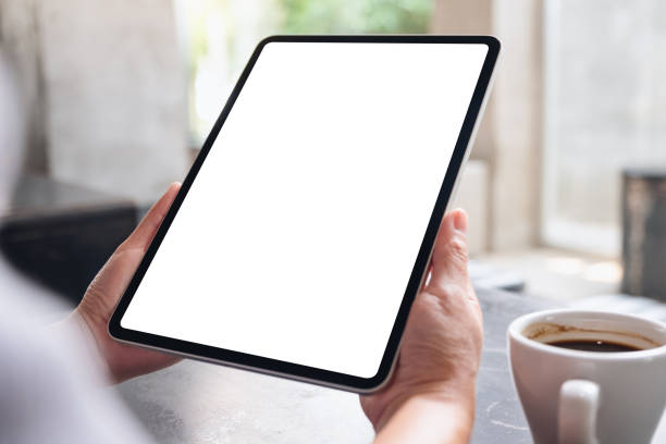 istock a woman holding digital tablet with blank white desktop screen in cafe 1323298060