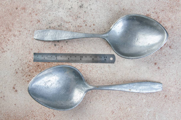 istock Huge aluminum spoons on concrete background. 1323301429
