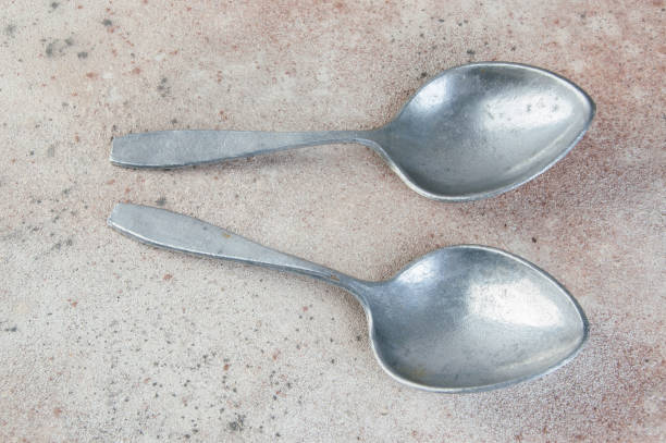 istock Huge aluminum spoons on concrete background. 1323302516