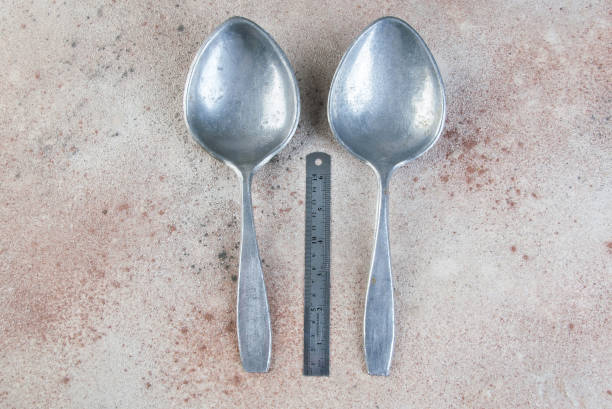 istock Huge aluminum spoons on concrete background. 1323302524