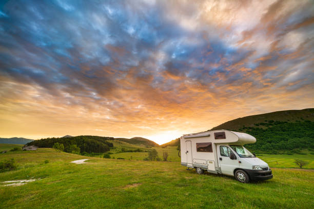 istock Sunset dramatic sky over camper van in Montelago highlands, Marche, Italy. Epic clouds above unique hills and mountains landscape, alternative vanlife vacation concept. 1323302713