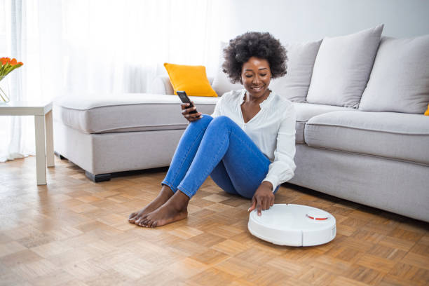 istock Woman Using Home Robot Cleaning App 1323303718