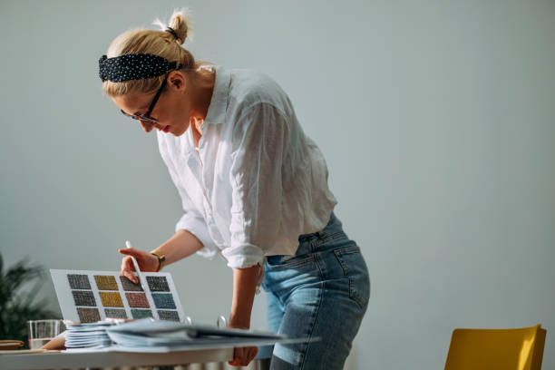 istock Young Woman Choosing Colour Palette For New Flat Leaning On Table 1323304718