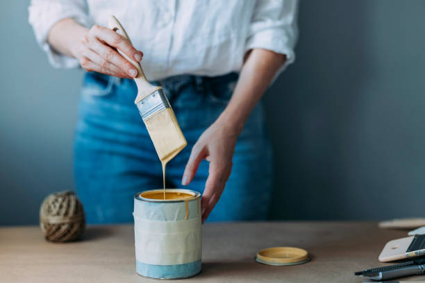 istock Woman Holding Brush And Testing Yellow Paint 1323304745
