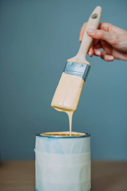 istock Woman Testing Yellow Paint With Paintbrush 1323304758