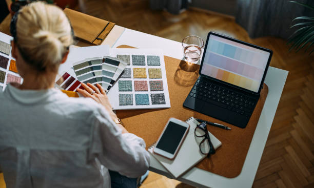 istock Young Woman With Computer At The Table Choosing Colour Palette For New Interior 1323304760