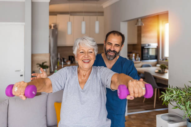 femme âgée après un avc à une maison de soins infirmiers faisant de l’exercice avec un physiothérapeute professionnel - scrubs professional sport indoors healthcare and medicine photos et images de collection