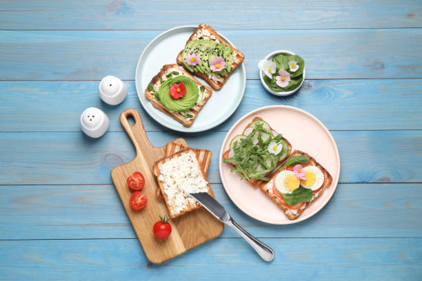istock Different delicious sandwiches on light blue wooden table, flat lay 1323307608