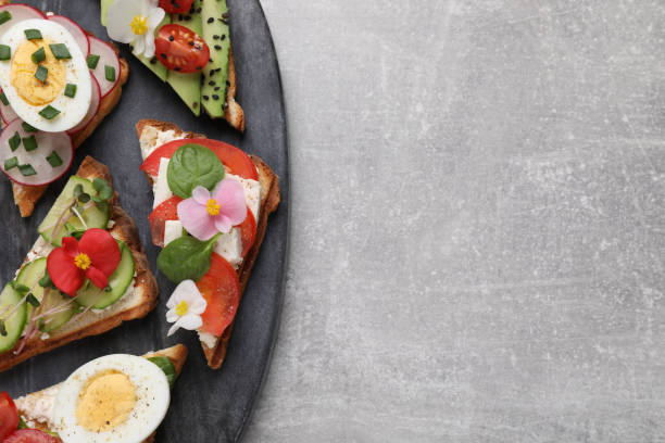 istock Different tasty sandwiches served on grey table, top view. Space for text 1323307772