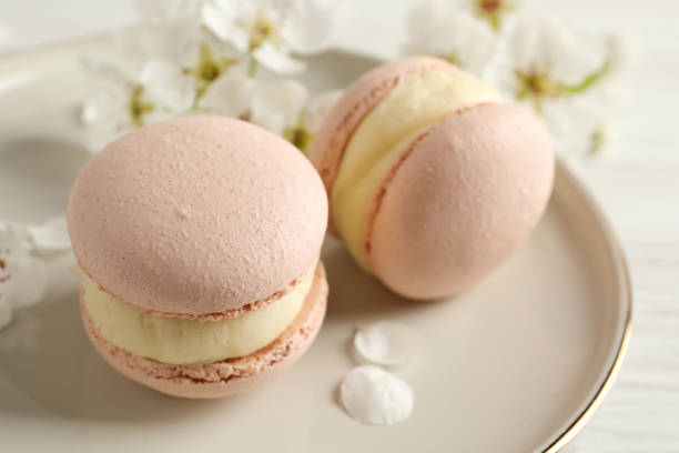 deliciosos macarons rosados y flores sobre mesa blanca, primer plano - comida francesa fotografías e imágenes de stock