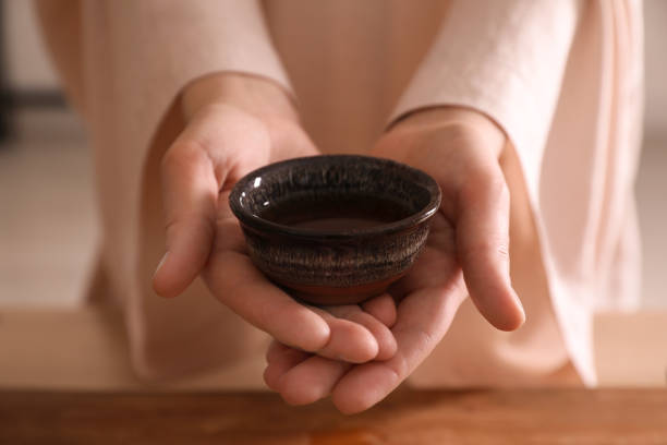 istock Master offering cup of freshly brewed tea during traditional ceremony at table, closeup 1323307962