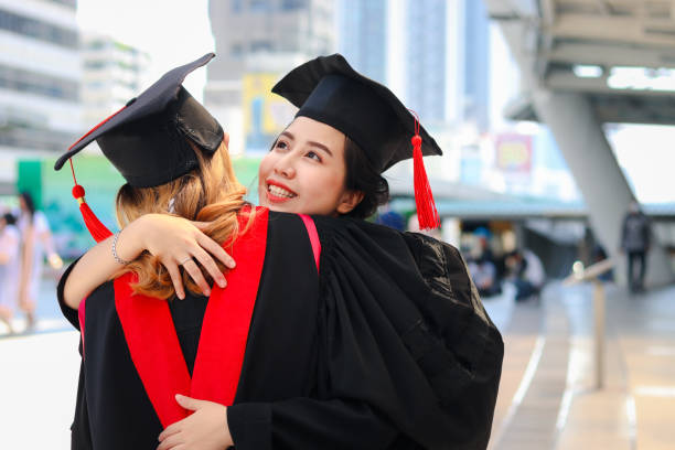 istock Two happy graduated women students with square academic hat cap hugging each other, people celebrating successful education and congratulating with friend on commencement graduation day when finished studies for university or college. 1323309209