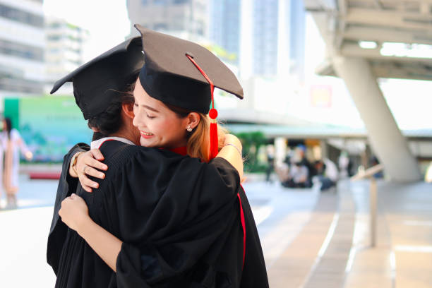 istock Two happy graduated women students with square academic hat cap hugging each other, people celebrating successful education and congratulating with friend on commencement graduation day when finished studies for university or college. 1323309211