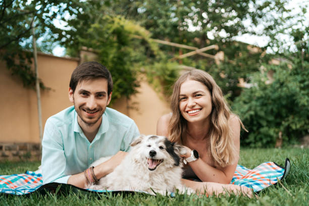 istock Beautiful couple with a dog on the grass 1323310222