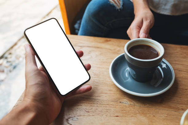 istock a man holding and showing mobile phone with blank black desktop screen to others 1323311189