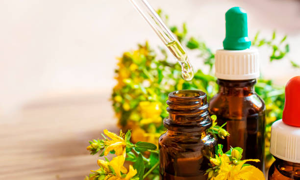 St. John's wort flower oil in glass bottle. selective focus St. John's wort flower oil in glass bottle. selective focus.nature st john's plant stock pictures, royalty-free photos & images