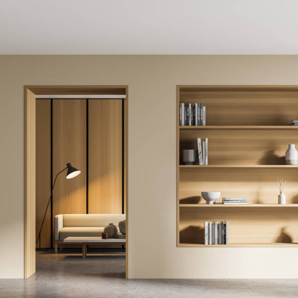 istock Beige living room interior with bookshelf and sofa behind door 1323315621
