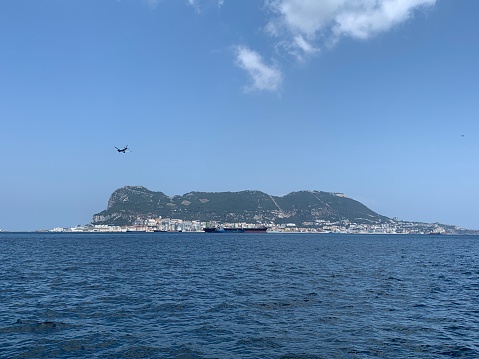 Airplane on final descent to land at the Rock of Gibraltar