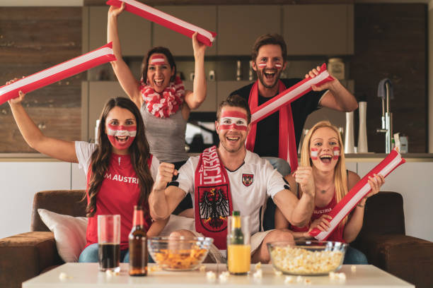 istock cheering austrian soccer fans watching live match at home 1323317227