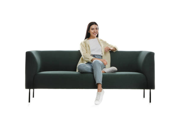 istock Young woman relaxing on comfortable green sofa against white background 1323319793
