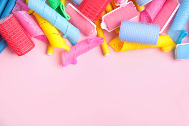 istock Many different hair curlers on pink background, flat lay. Space for text 1323321152