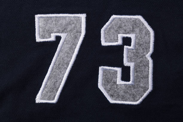 istock Numbers seven 7 and three 3 in fabric on a blue T-shirt. 1323323310