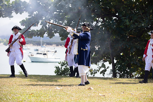 an actor playing captain cook firing a musket