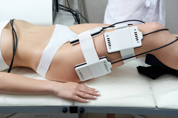 Beautiful woman getting electro stimulation therapy. Laser lipo equipment. Cosmetic fat reduce treatment. Anti cellulite procedure Beautiful woman getting electro stimulation therapy. Laser lipo equipment. Cosmetic fat reduce treatment. Woman in medicine salon. Anti cellulite procedure. electrode stock pictures, royalty-free photos & images