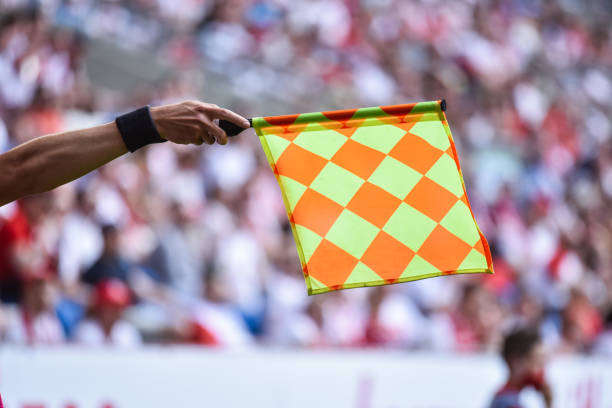 football referee with flag Hand of assistant of football referee with raised flag. offside stock pictures, royalty-free photos & images