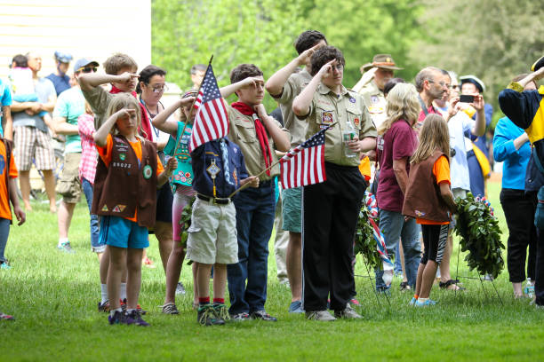 boy scouts y girl scouts saludando en la ceremonia del día de los caídos celebrada en lexington, ma el martes, domingo, 24 de mayo de 2015 - child patriotism saluting flag fotografías e imágenes de stock